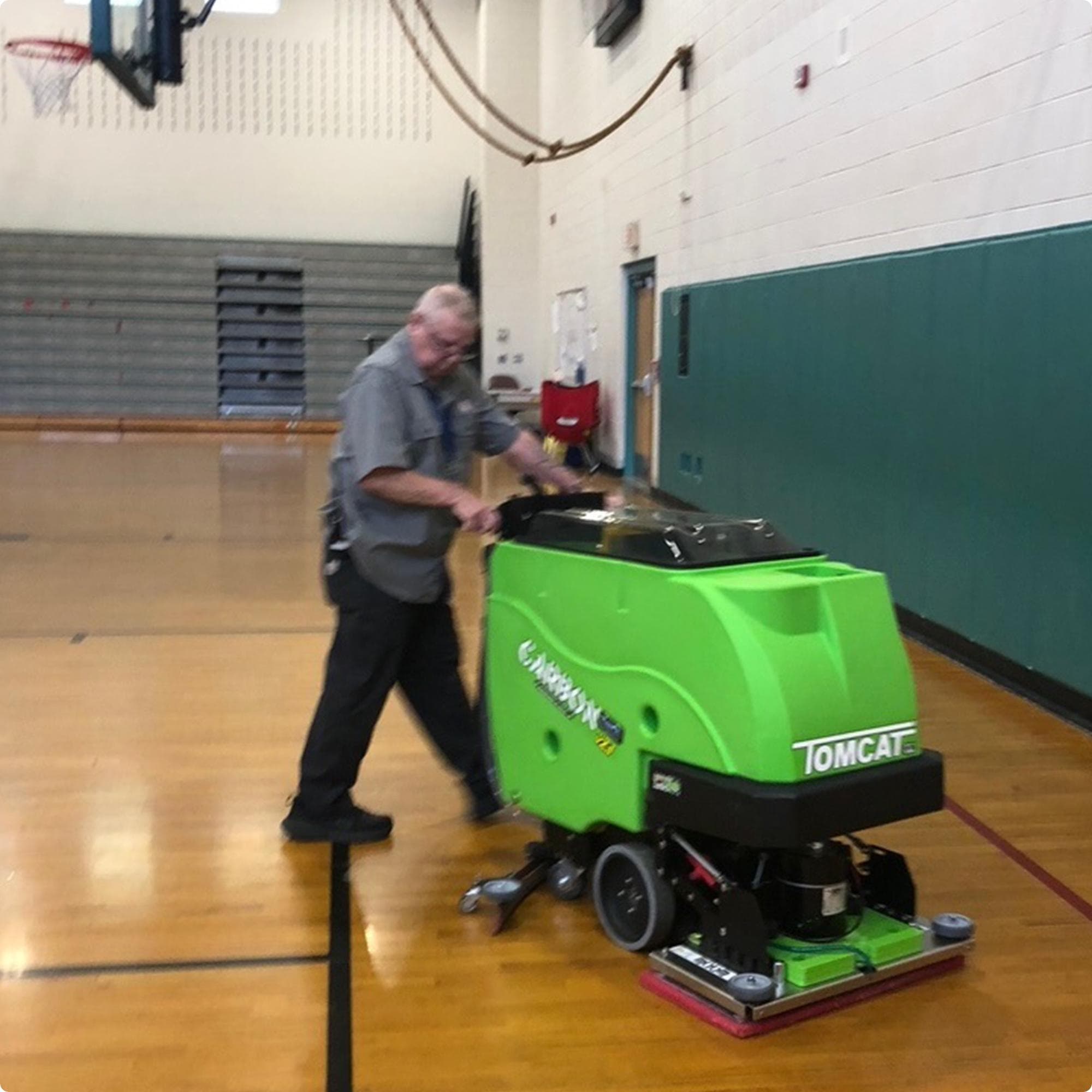 Tomcat Carbon 28" EDGE walk behind  floor scubber with anti-microbial tank option cleaning a wood floor in a gymnasium IMG0002