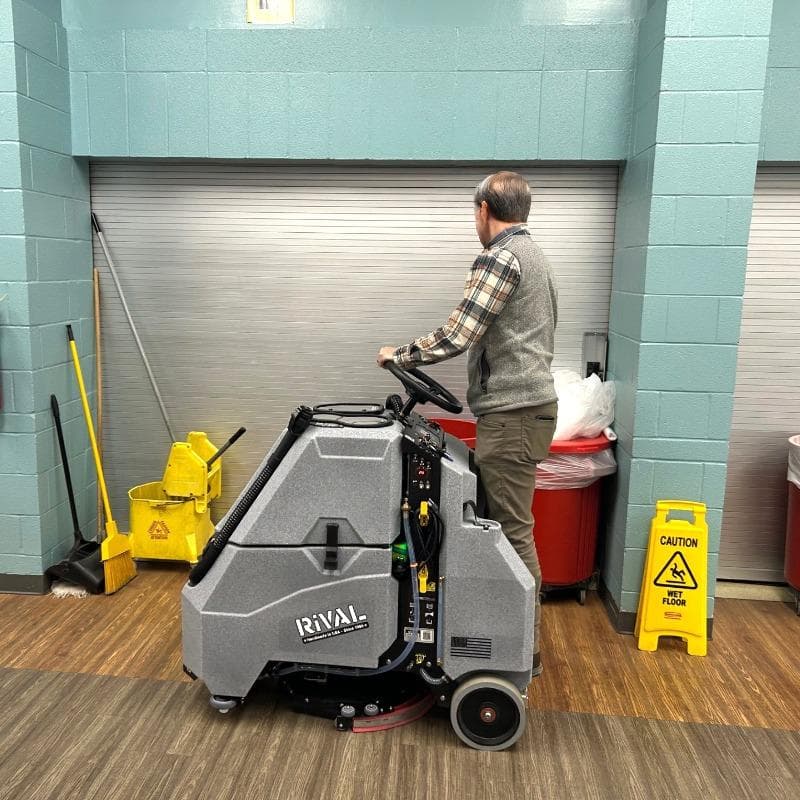 Tomcat Stand On Floor Scrubbers Rival cafeteria vinyl plank A Tomcat Rival stand on battery floor scrubber cleaning the luxury vinyl tile (LVT) floor of a school cafeteria in Austin, TX
